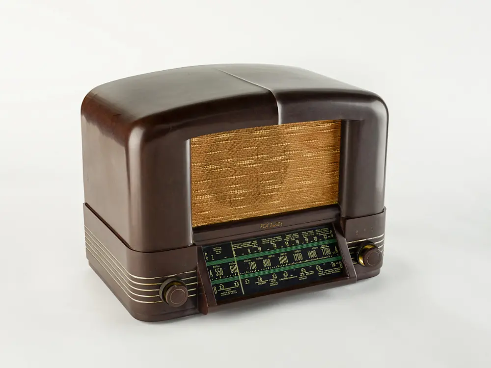 A small, vintage looking rectangular radio with rounded edges.