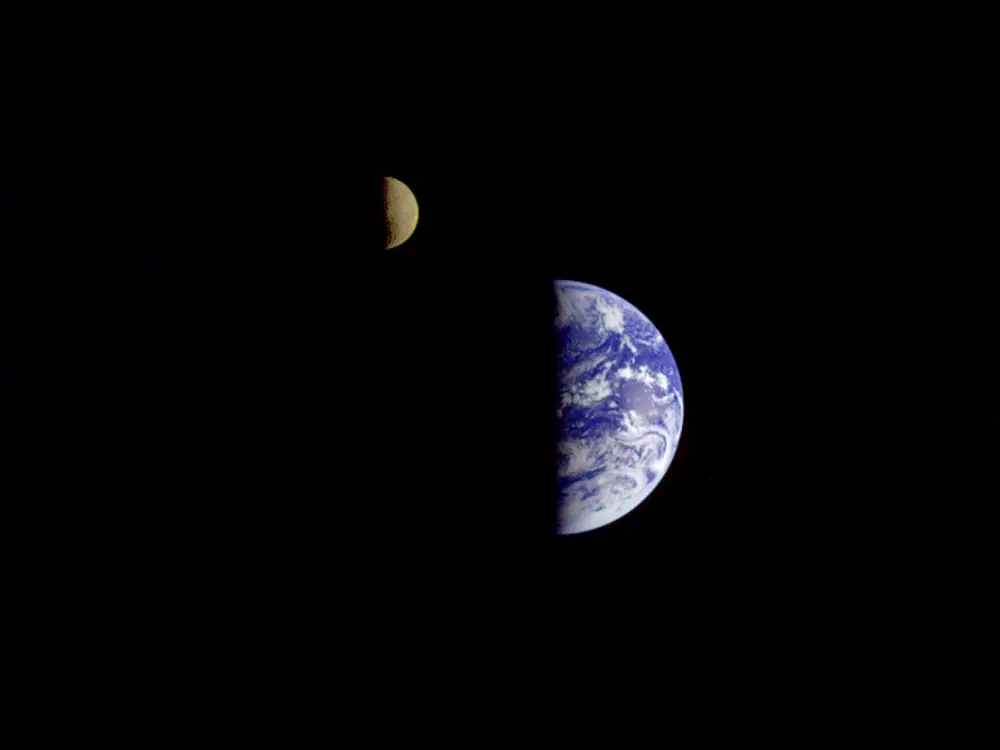 An image of the Earth and the Moon next to each other, the Moon just slightly to the northwest of the Earth. Only the right half of each body can be seen.