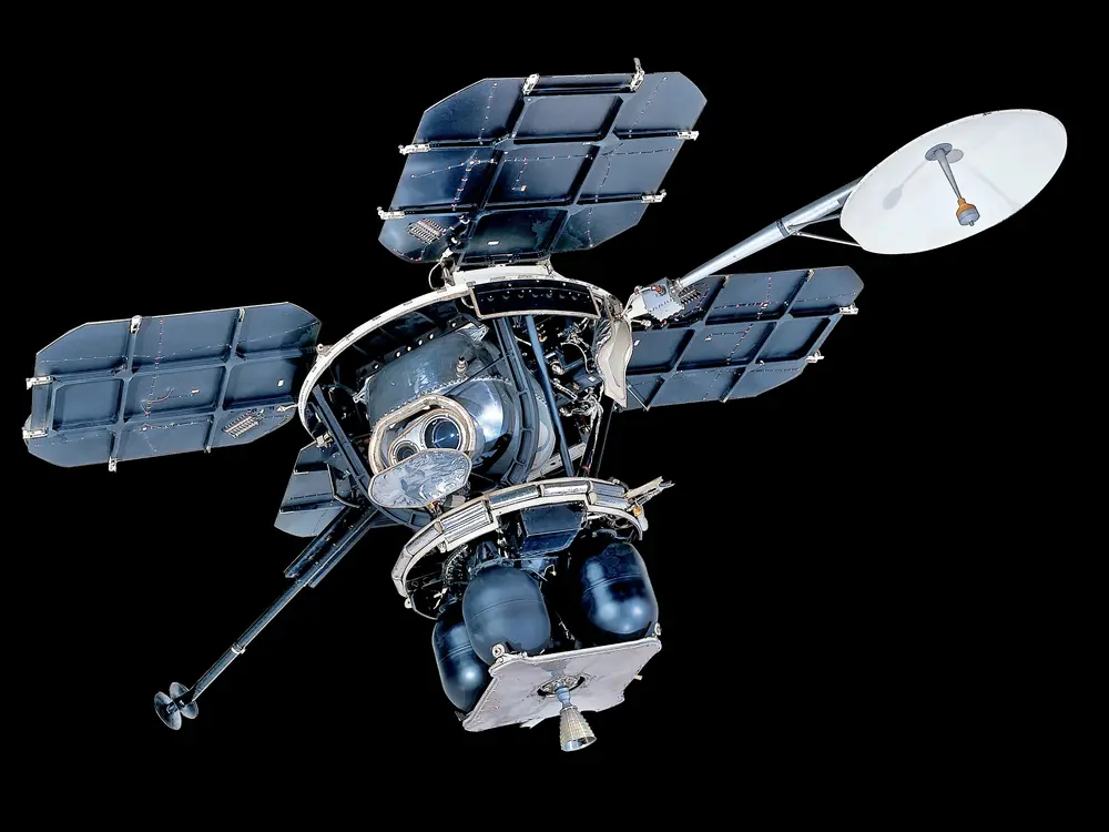 Four square solar panels constructed of aluminum frames and composite solar collectors, attached to a central body via aluminum struts. The Central bus consists of a variety of solid boxes and stalks with panels and other objects projecting from it. A tubular mast at the apex of the frame supports a rectangular a circular high gain antenna. A selection of instrument boxes, vernier rockets and their fuel containers, and the TV camera are attached to the frame.