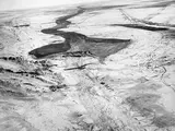An aerial photo of a once used dam and died out canals around it.