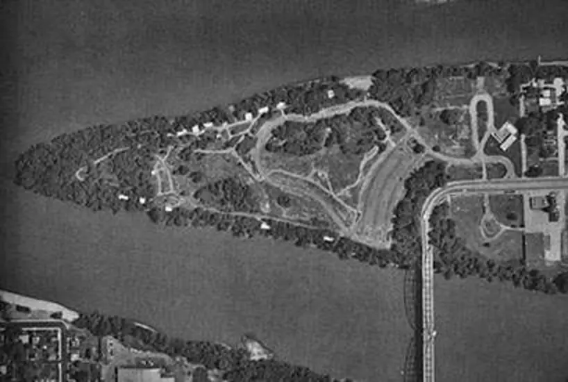 An aerial photo of a triangular shaped island that has a bridge connecting it to the mainland.